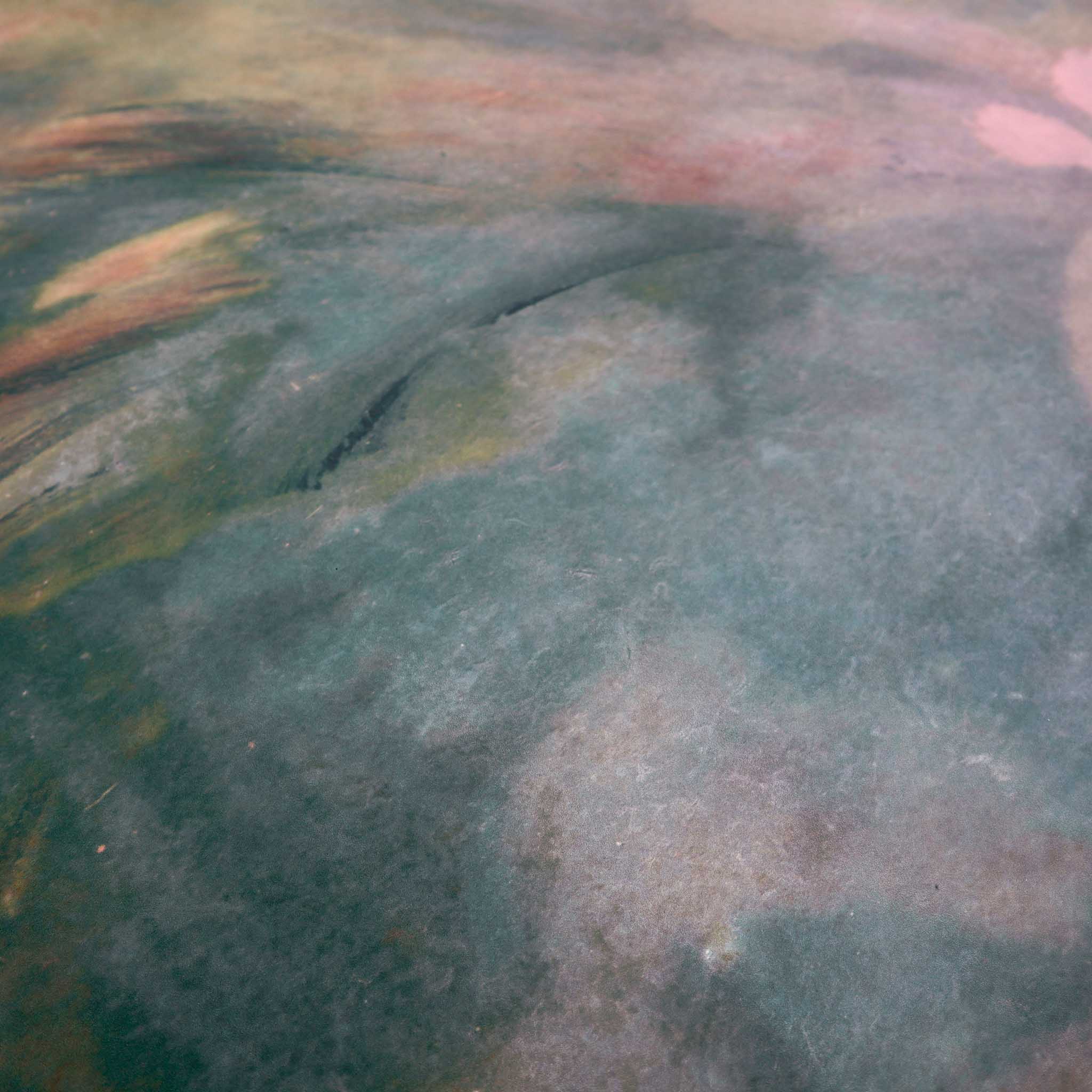 Close-up of a matte uncoated abstract wallpaper mural, featuring swirling dark greens, ember reds, and soft creams.