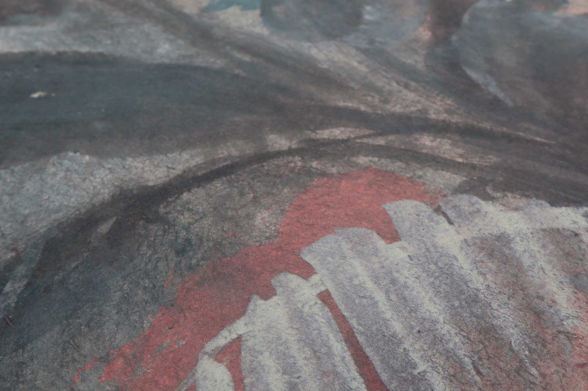 Close-up of a textured hand-painted mural featuring soft greys, dusty blues, and earth tones in an abstract style.