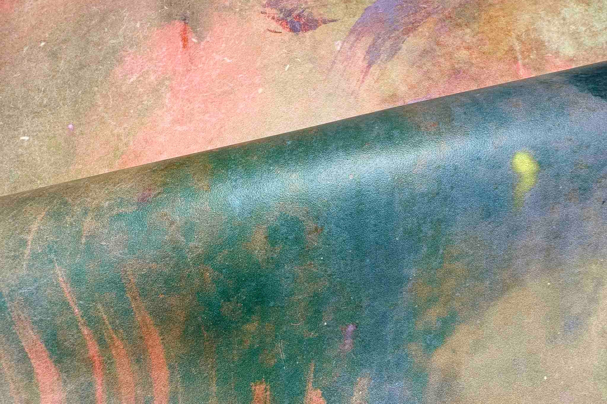 Close-up of a hand-painted panoramic wallpaper mural featuring warm ember reds and deep greens on a durable vinyl.