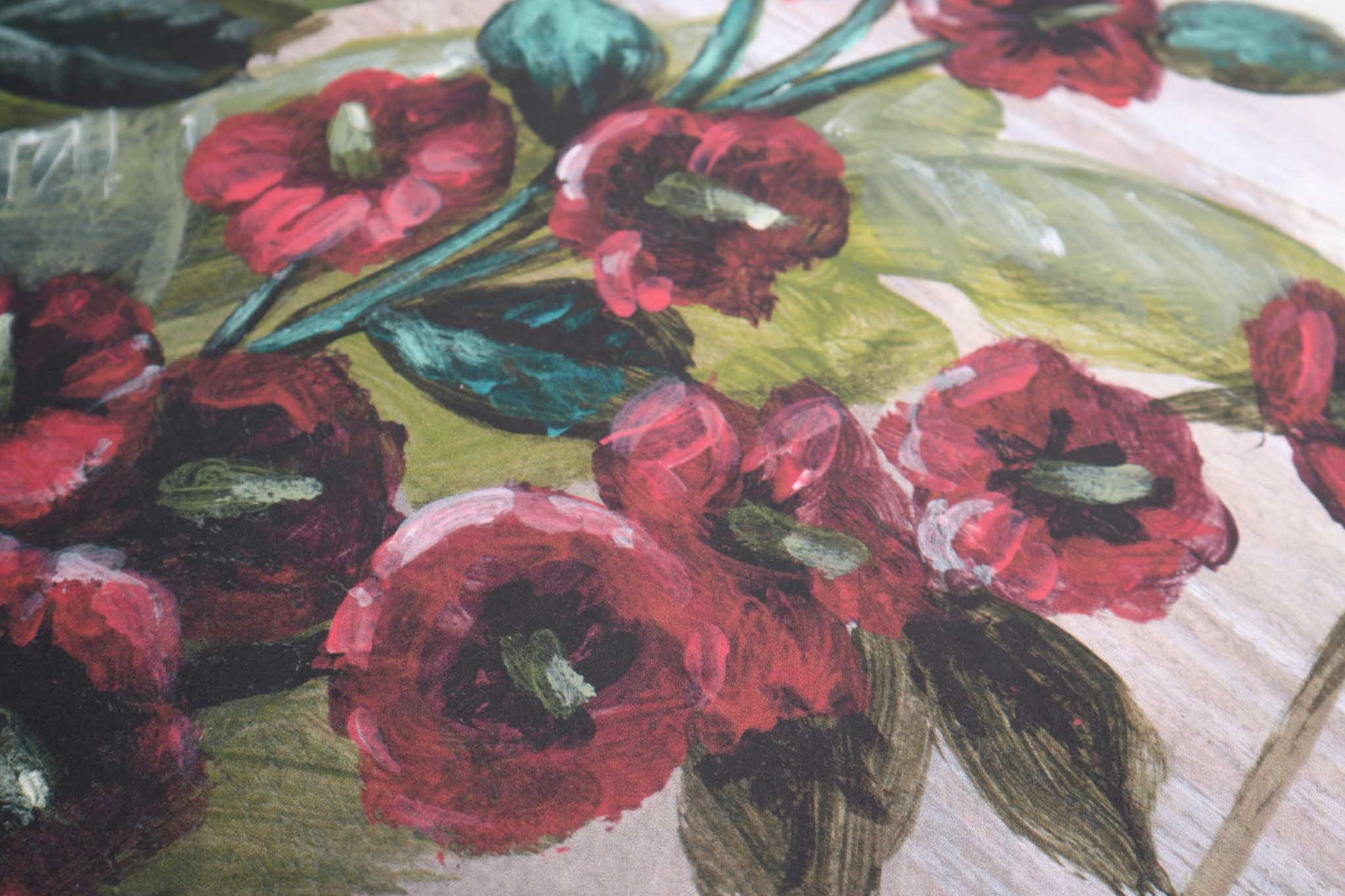 Close-up of a hand-painted wallpaper mural featuring vibrant red flowers and green leaves on a matte finish.