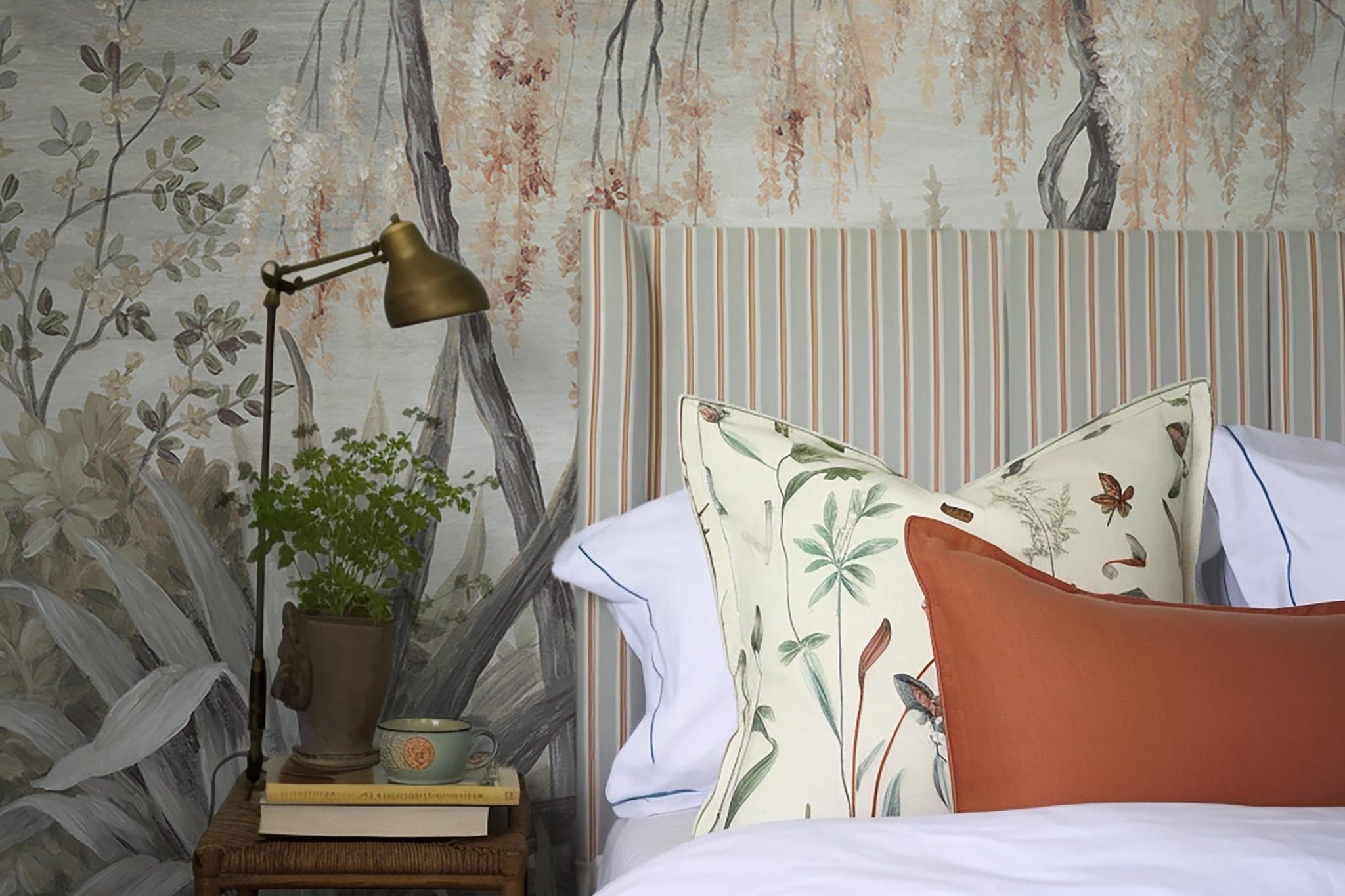 A cropped view of bedroom featuring a panoramic matte wallpaper mural of a lakeside scene in grey and peach.