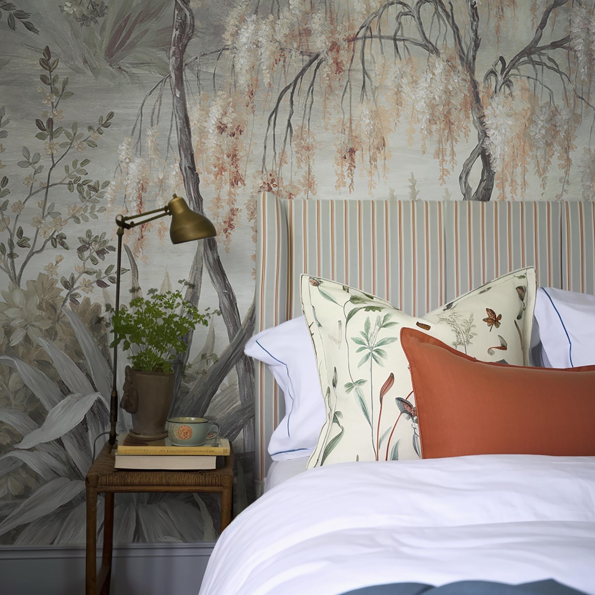 A cropped view of bedroom featuring a panoramic matte wallpaper mural of a lakeside scene in grey and peach.