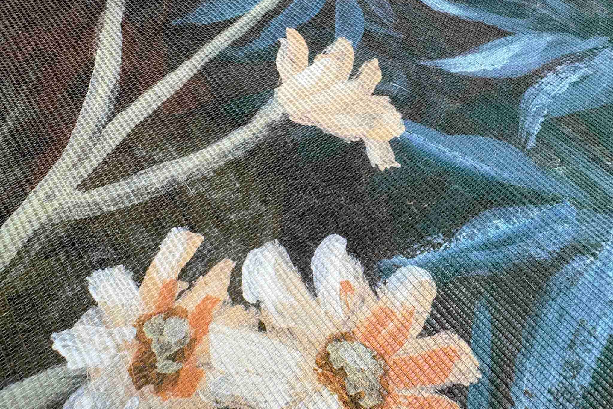 Close-up of floral mural on grasscloth, featuring soft blooms against a dark backdrop with textured weaving.