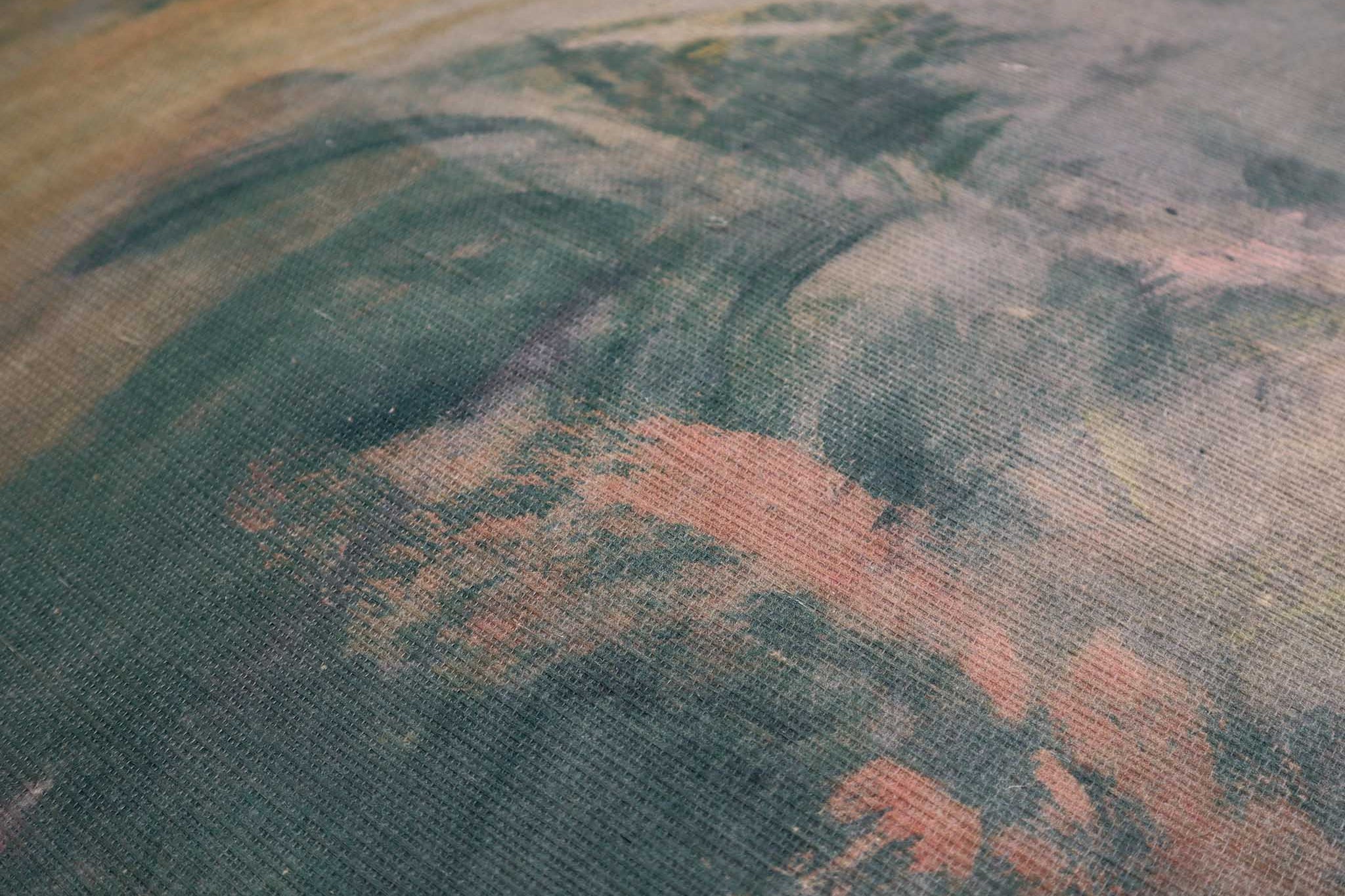 Close-up of a textured grasscloth wallpaper mural featuring abstract swirls in ember red, cream, and deep green tones.
