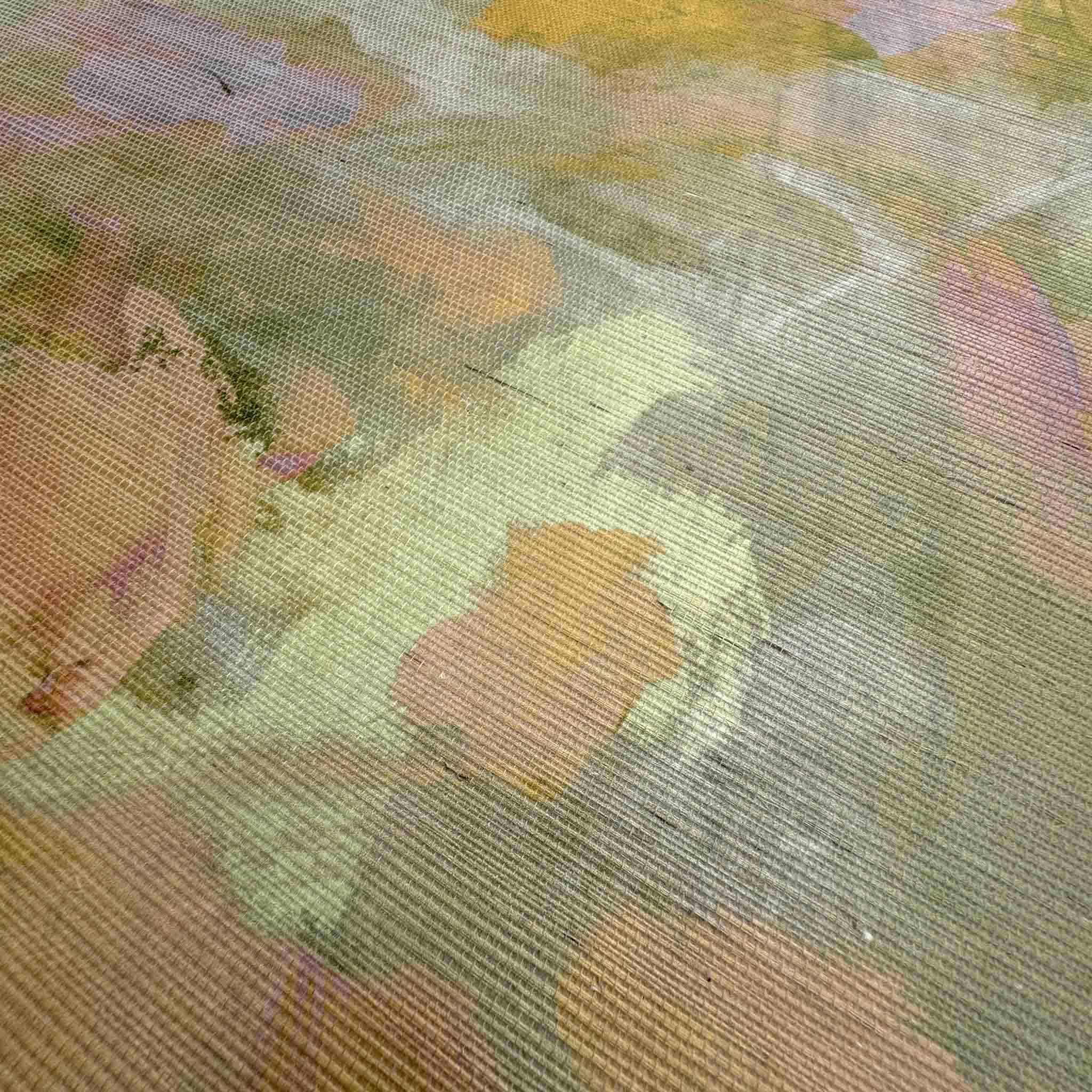 Close-up of a grasscloth wallpaper mural featuring abstract marks in honeyed golds, soft pinks, and lush greens.