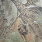 Close-up of a wallpaper mural with soft sandy hues and muted greens, featuring abstract tropical foliage on grasscloth.