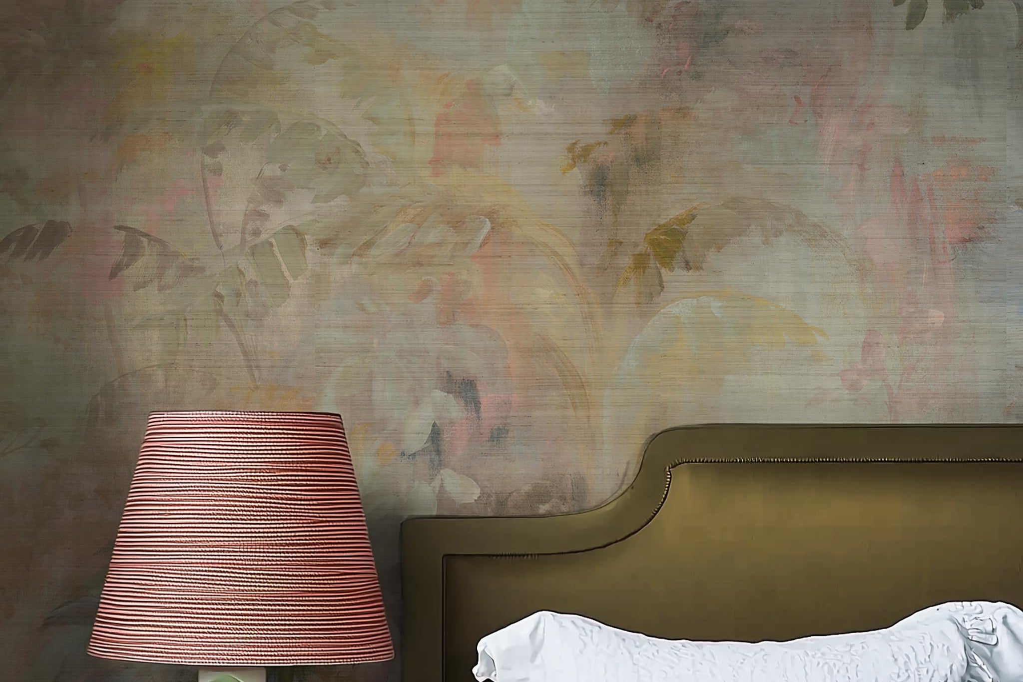 A cropped view of bedroom featuring a panoramic grasscloth wallpaper mural of a rainforest in blush and sky blue.
