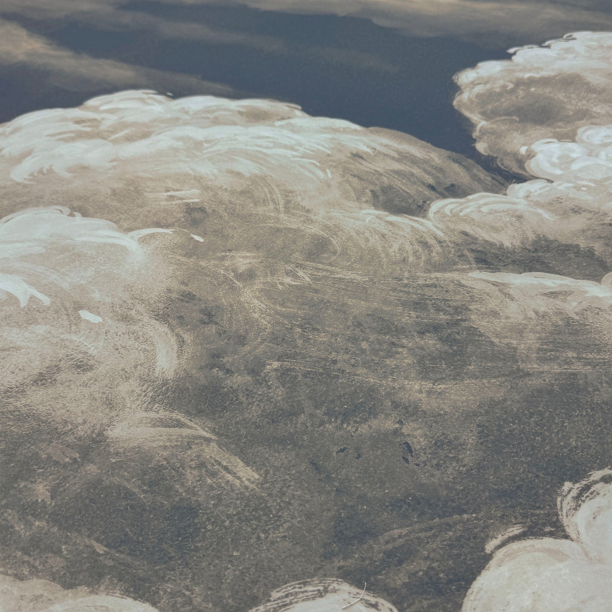 A close up view showing the detail of a matte wallpaper mural which features dramatic cream clouds