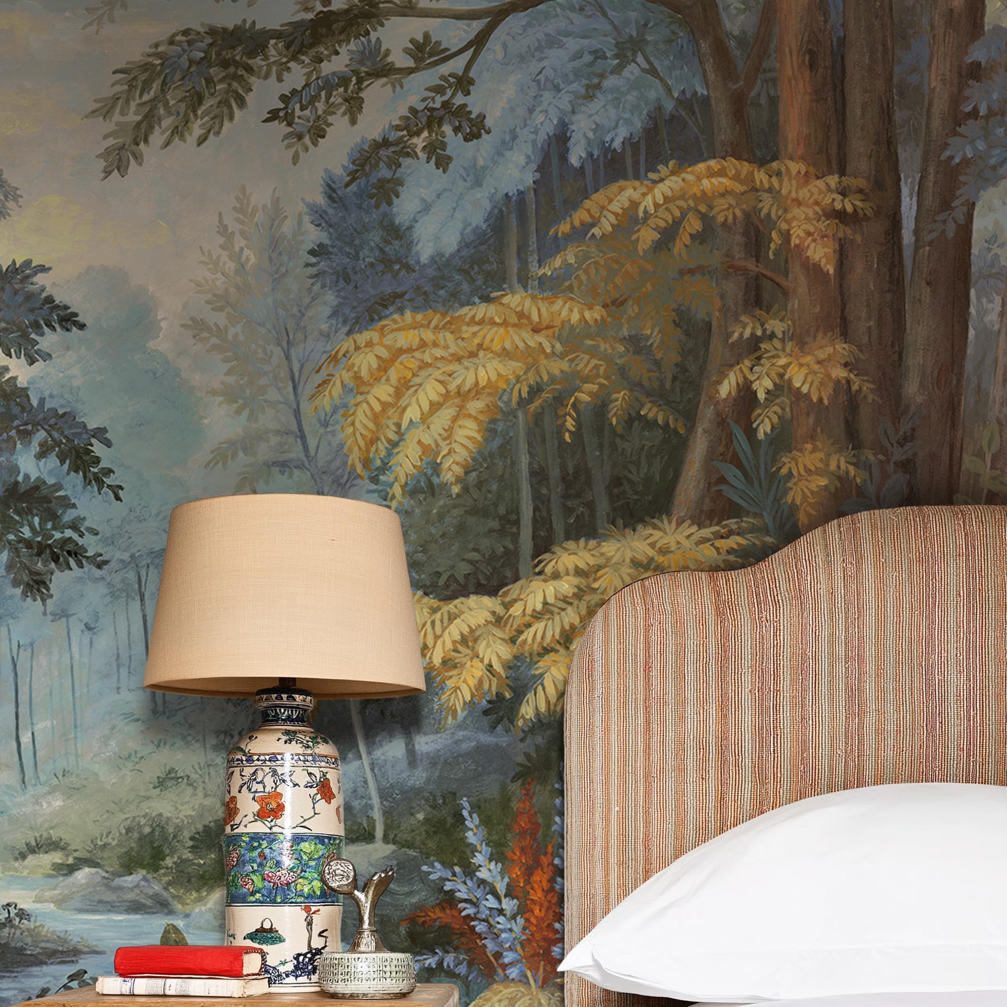 A cropped view of bedroom featuring a panoramic matte wallpaper mural of an enchanted forest in blue and rust.