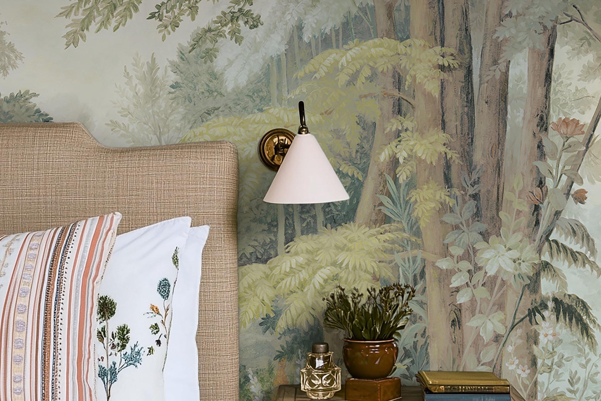 A cropped view of bedroom featuring a panoramic matte wallpaper mural of an airy woodland in sage, yellow, and mist.
