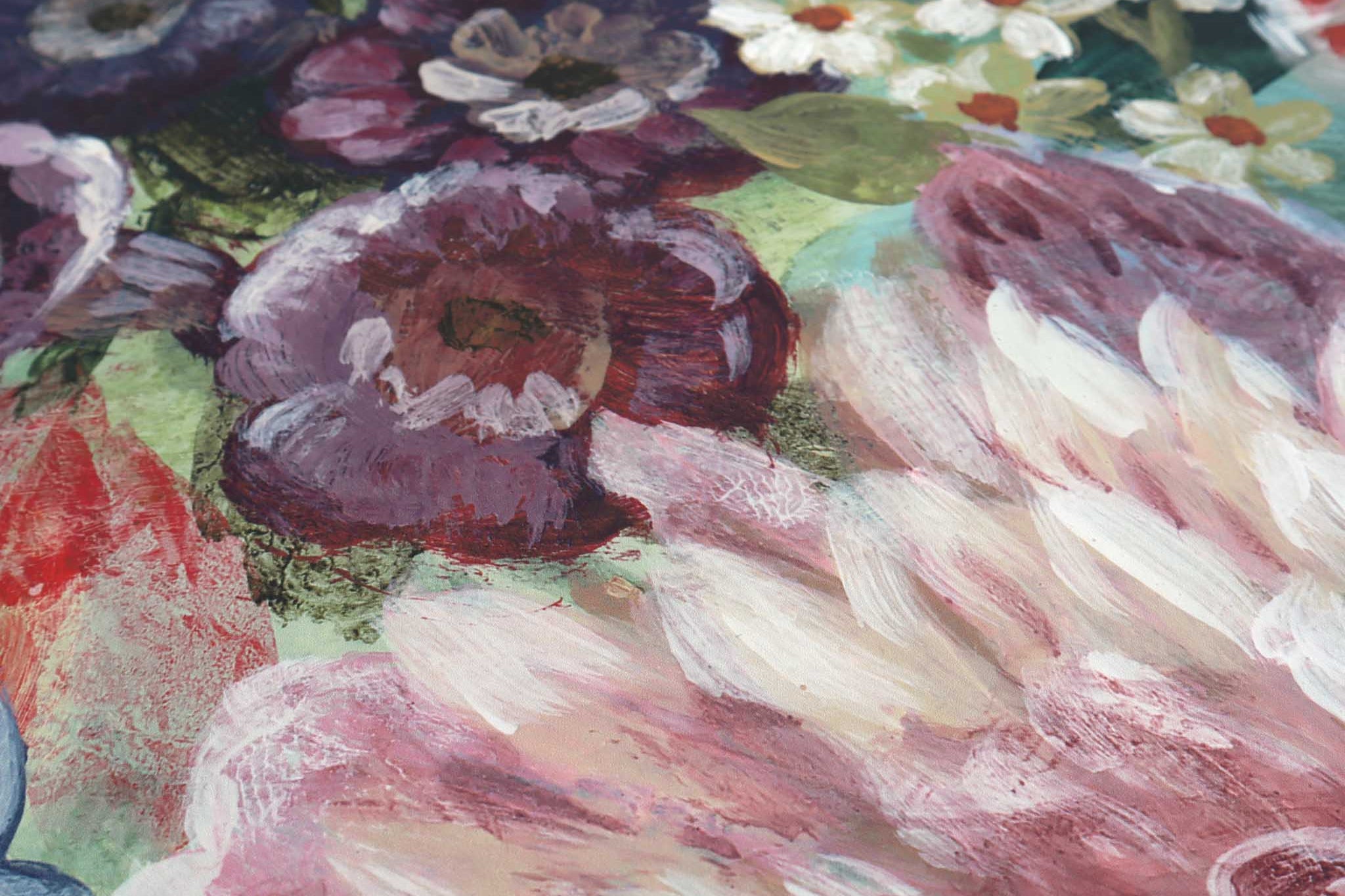 Close-up of a vibrant floral mural featuring rich greens, reds, purples, and soft pinks on a matte non-woven substrate.