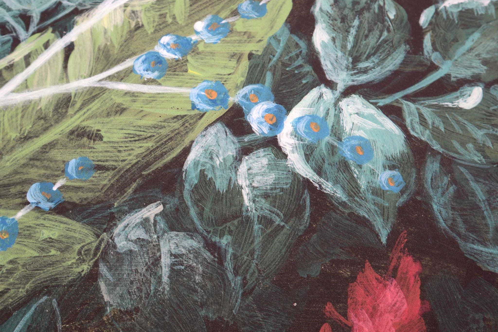 Close-up of a bespoke floral wallpaper mural featuring lush green leaves and vibrant blue flowers on a matte finish.