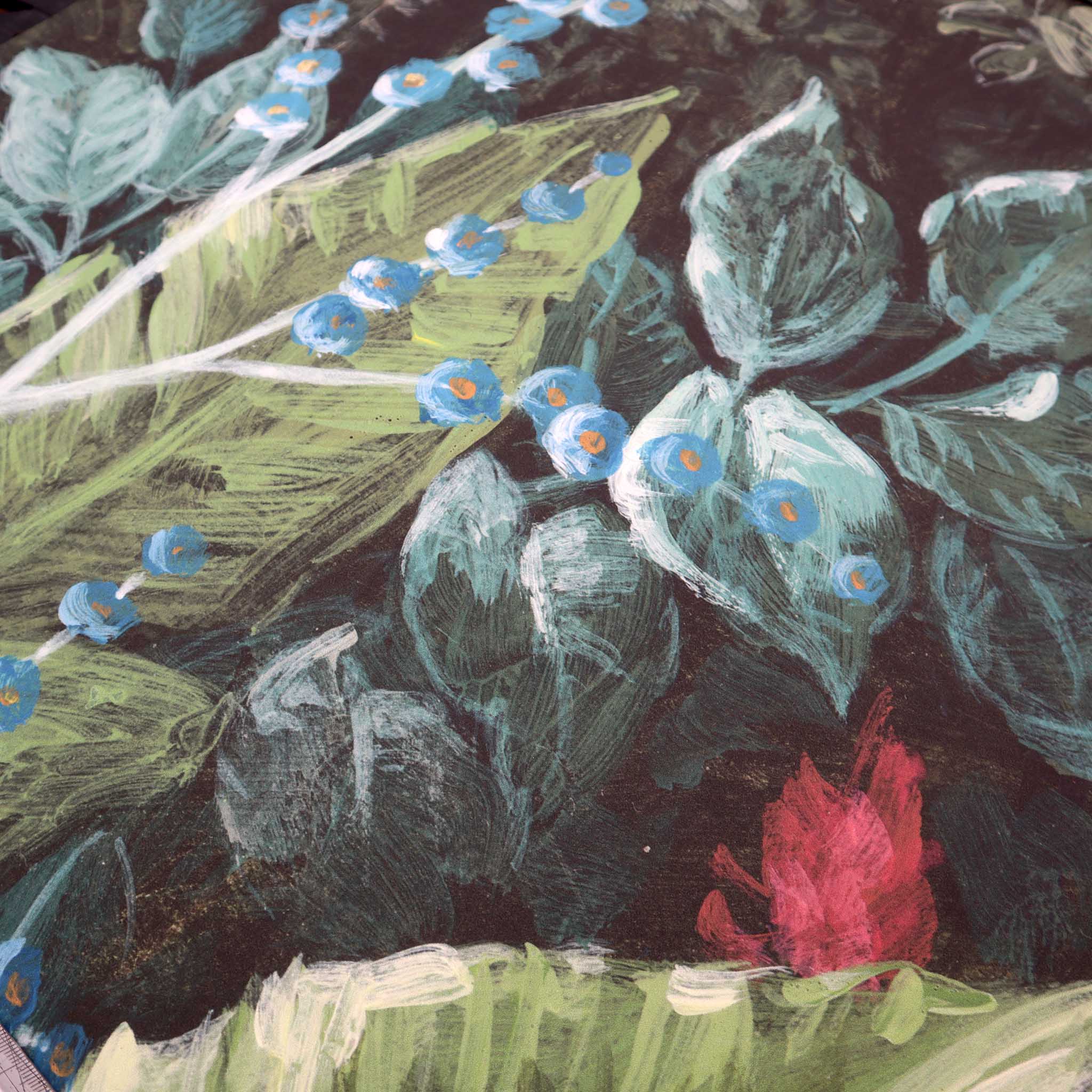 Close-up of a bespoke floral wallpaper mural featuring lush green leaves and vibrant blue flowers on a matte finish.