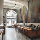 An interior restaurant featuring a panoramic vinyl wallpaper mural of an abstract haze in charcoal and ash.