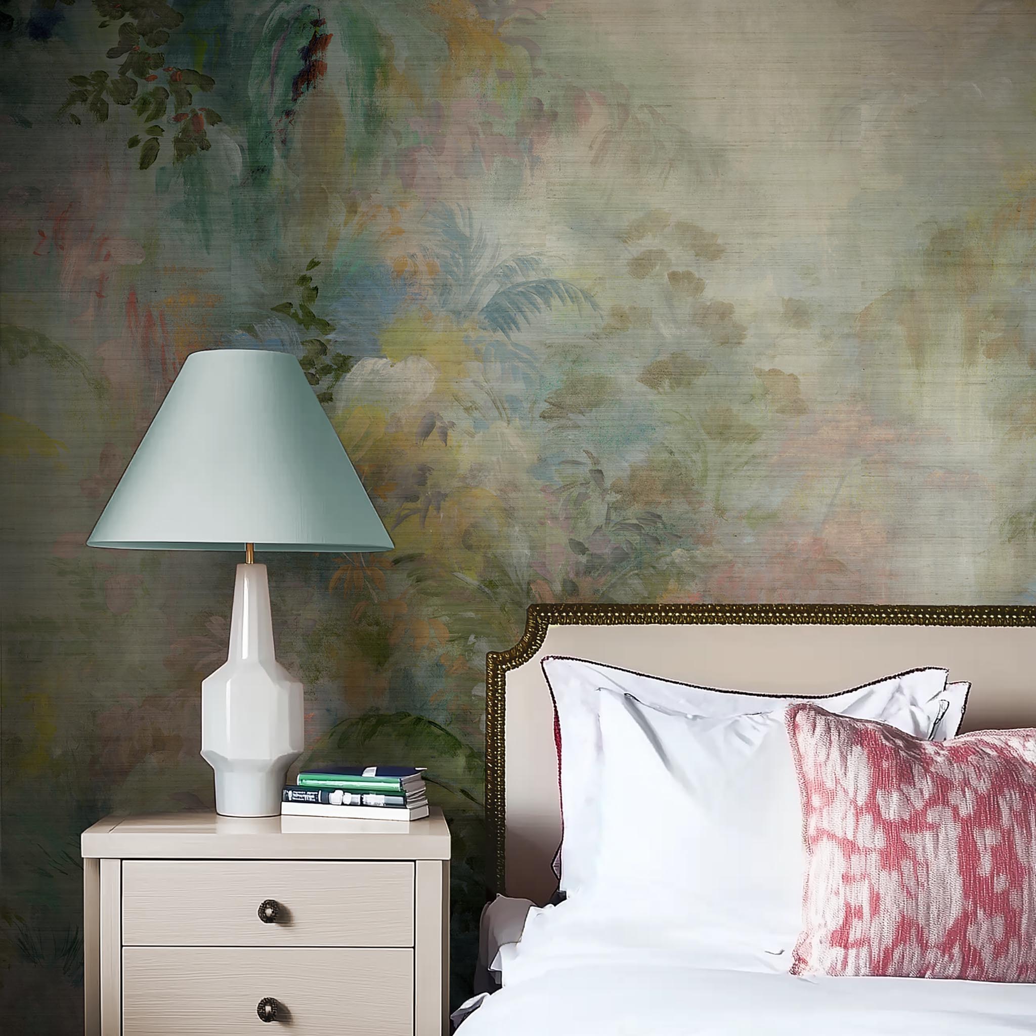 A cropped view of bedroom featuring a panoramic grasscloth wallpaper mural of a rainforest in green, coral, and gold.