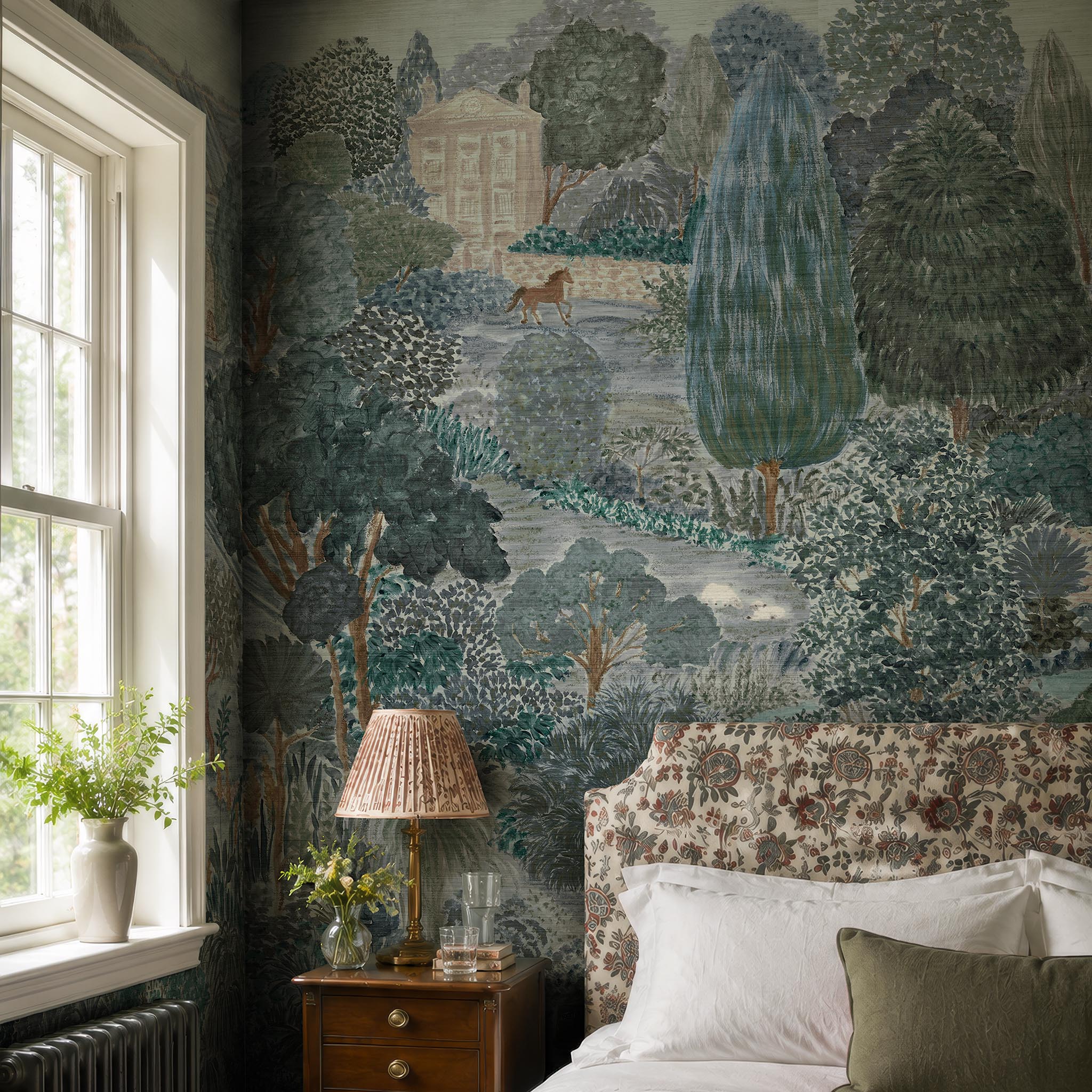 An interior bedroom featuring a panoramic grasscloth wallpaper mural of a countryside in teal, sea green and slate