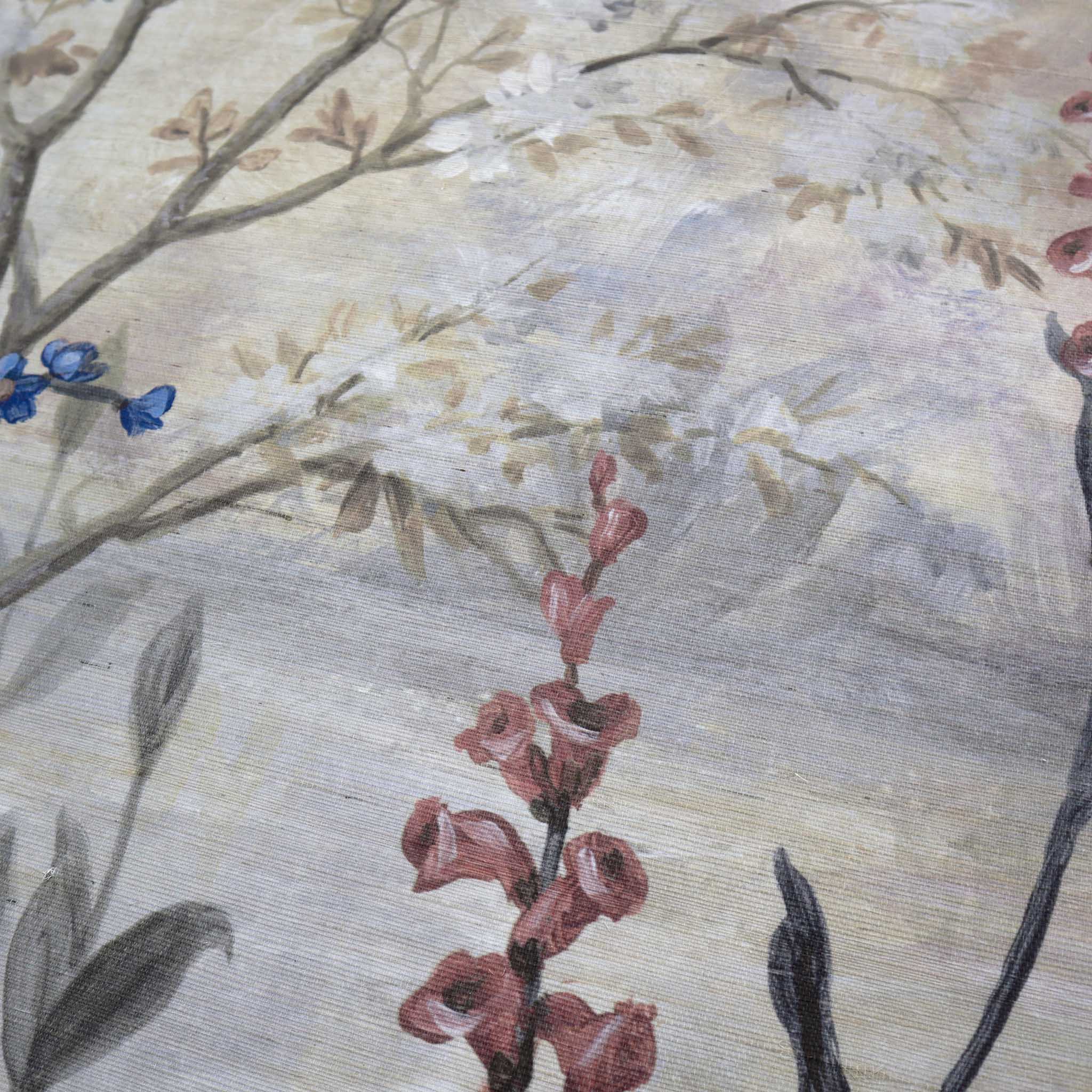 Close-up of a hand-painted floral mural on textured grasscloth wallpaper, featuring soft hues of grey, peach, and blue.