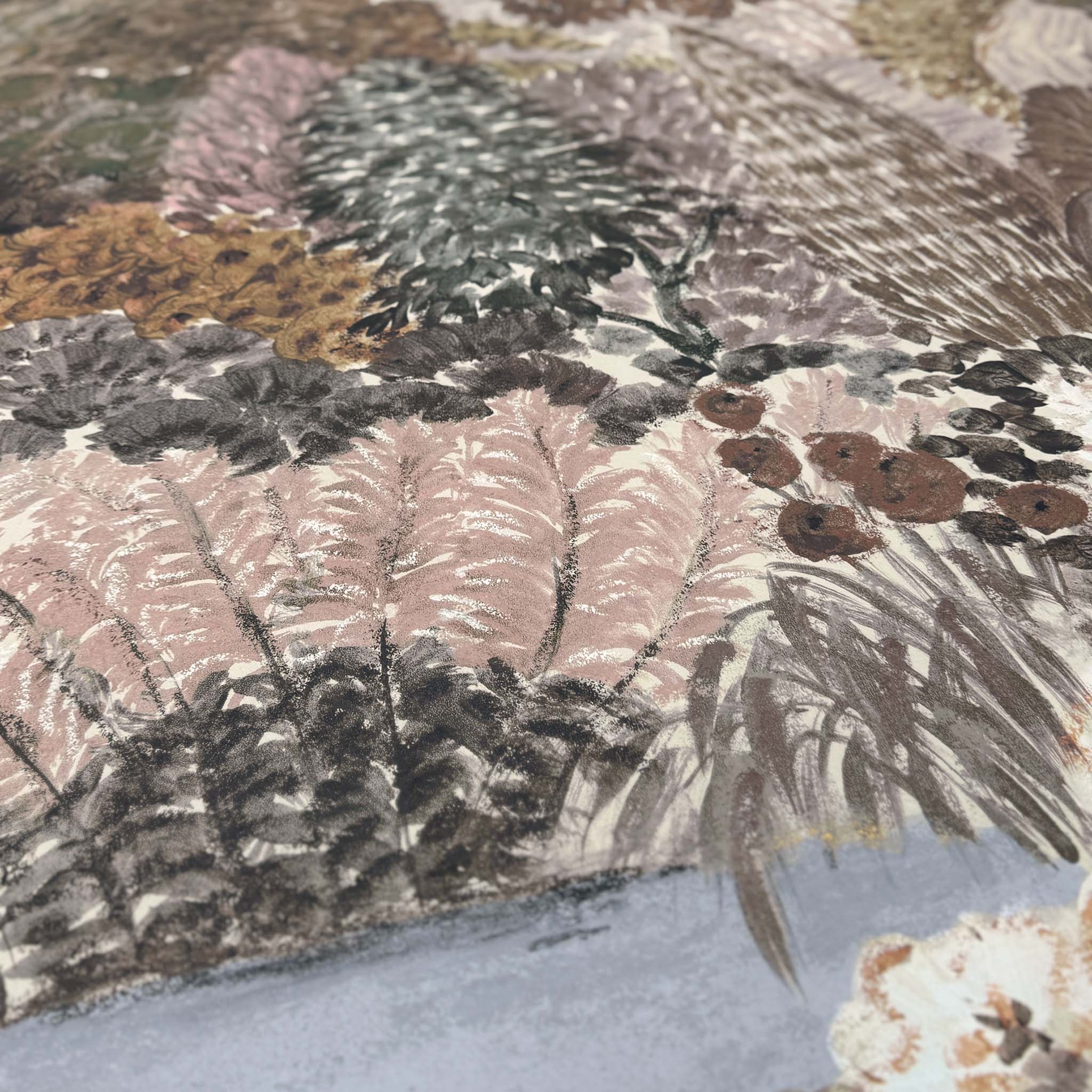 A close up view showing the detail of a matte wallpaper mural which features warm clays, soft plum, and rusted greens