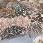 A close up view showing the detail of a matte wallpaper mural which features warm clays, soft plum, and rusted greens