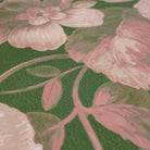 A close up view showing the detail of a matte wallpaper mural which features rosy florals on lush green