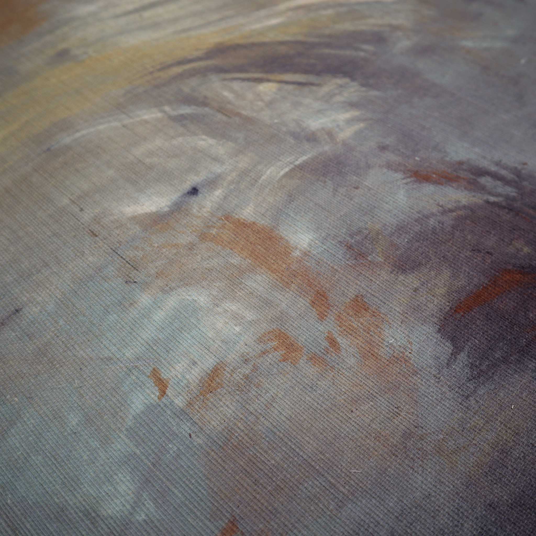 Close-up of a textured grasscloth wallpaper mural in rich shades of charcoal, rust, and ochre, featuring abstract design.