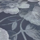 A close up view showing the detail of a matte wallpaper mural which features moonlit florals on deep navy
