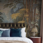 A cropped view of bedroom featuring a panoramic grasscloth wallpaper mural of an enchanted forest in blue and rust.