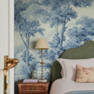 A cropped view of bedroom featuring a panoramic matte wallpaper mural of soft blue woodland