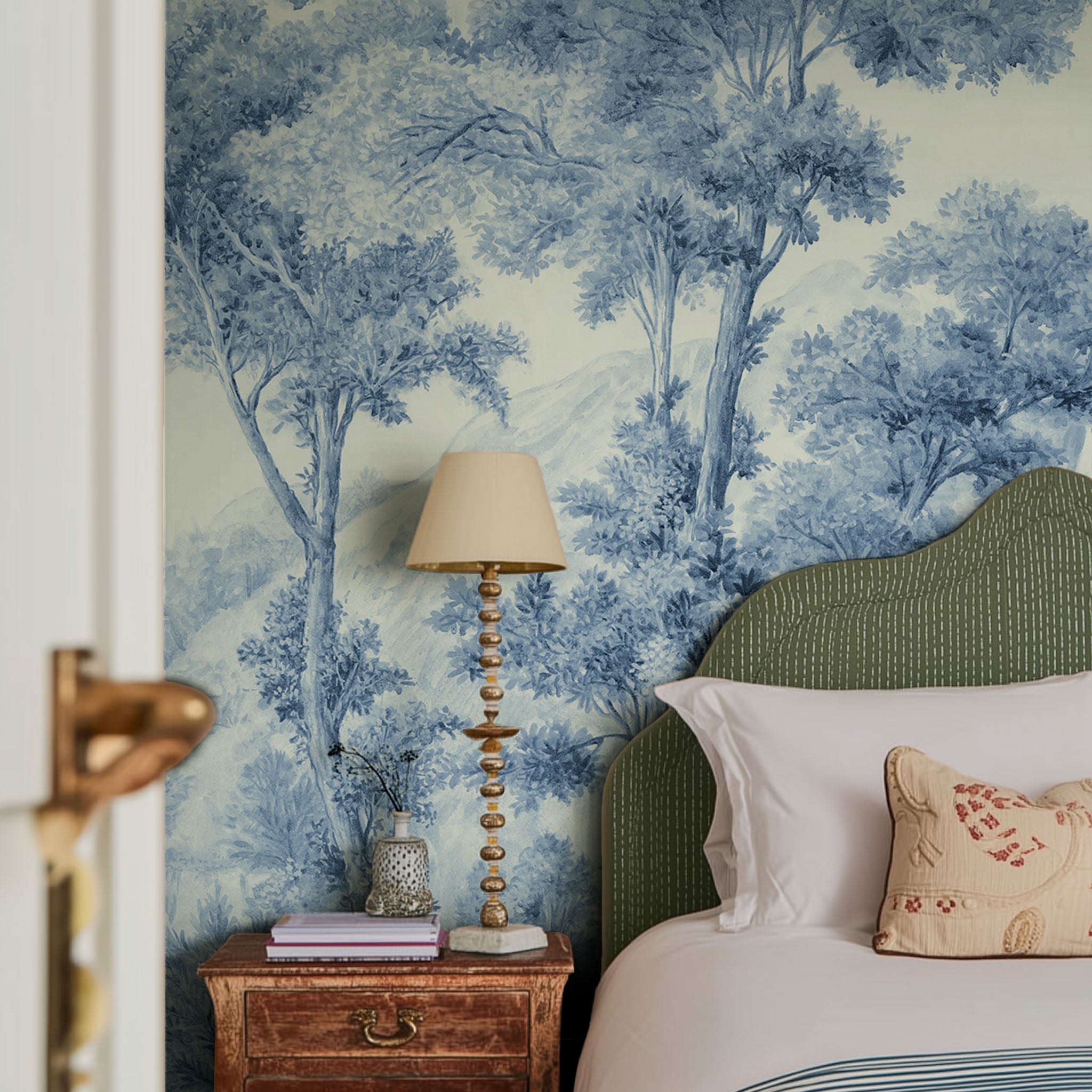 A cropped view of bedroom featuring a panoramic matte wallpaper mural of soft blue woodland