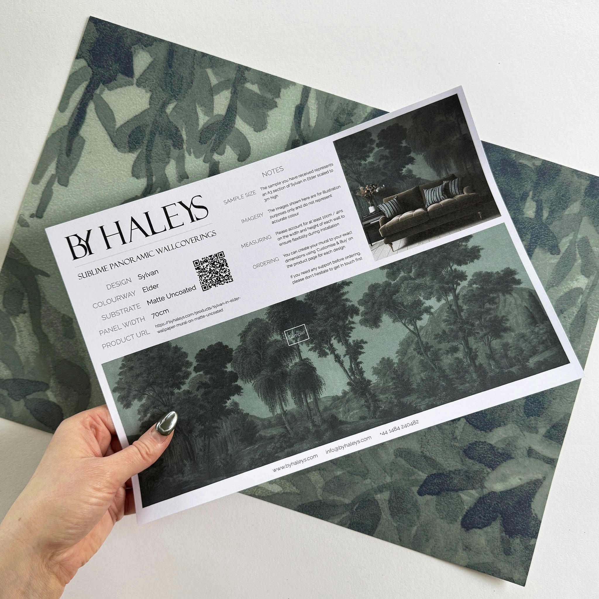 A hand showing information for a matte wallpaper mural sample which features deep woodland