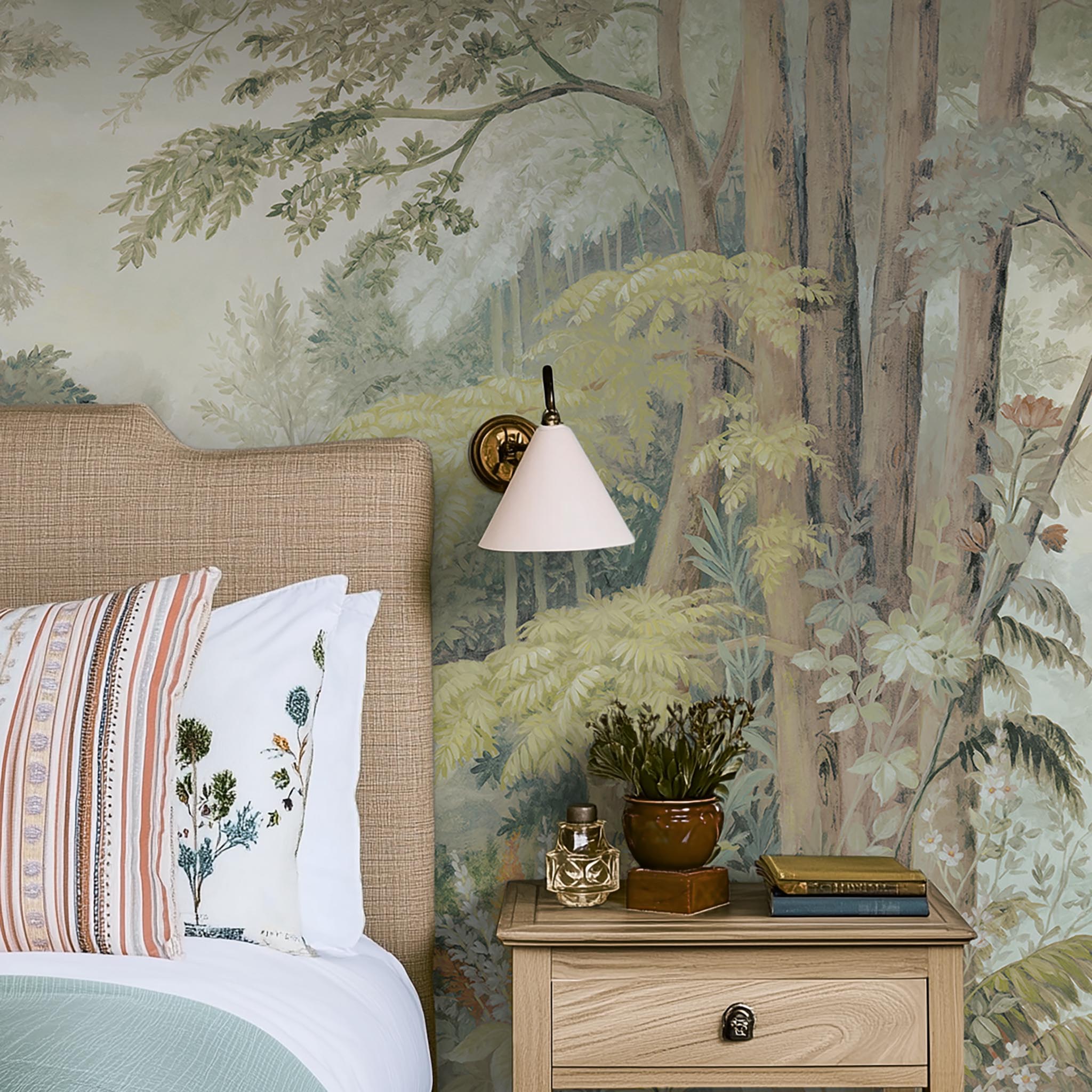 A cropped view of bedroom featuring a panoramic matte wallpaper mural of an airy woodland in sage, yellow, and mist.