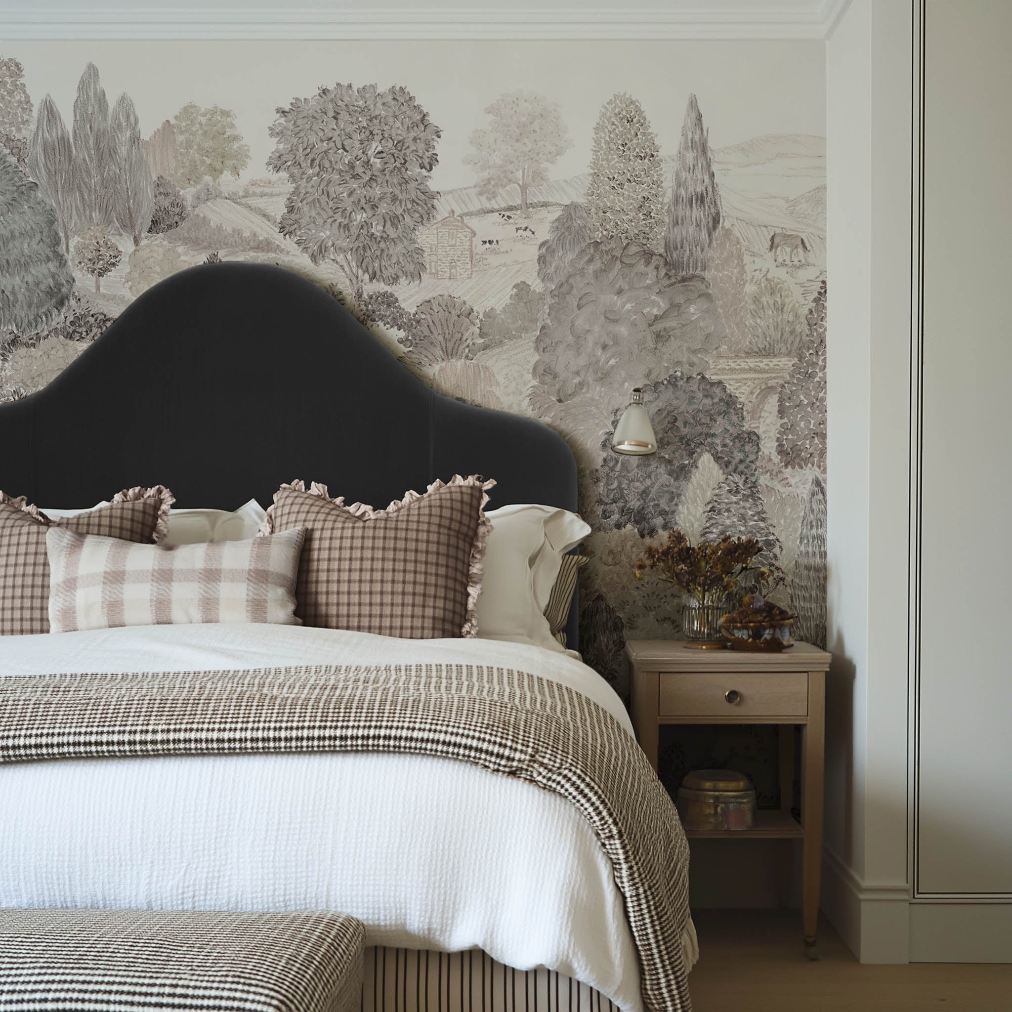 A cropped view of a bedroom featuring a panoramic matte wallpaper mural of almond, dusty rose, and mist countryside scene