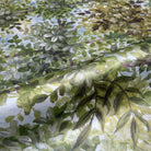 A close up view showing the detail of a pearlescent wallpaper mural which features bergamot-green mural with layered foliage and soft light.