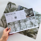 A hand showing information for a pearlescent wallpaper mural sample which features sunlit conservatory mural in chamomile & sage tones.