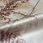 A close up view showing the detail of a pearlescent wallpaper mural which features saffron toned mural with climbing foliage and vintage glass.