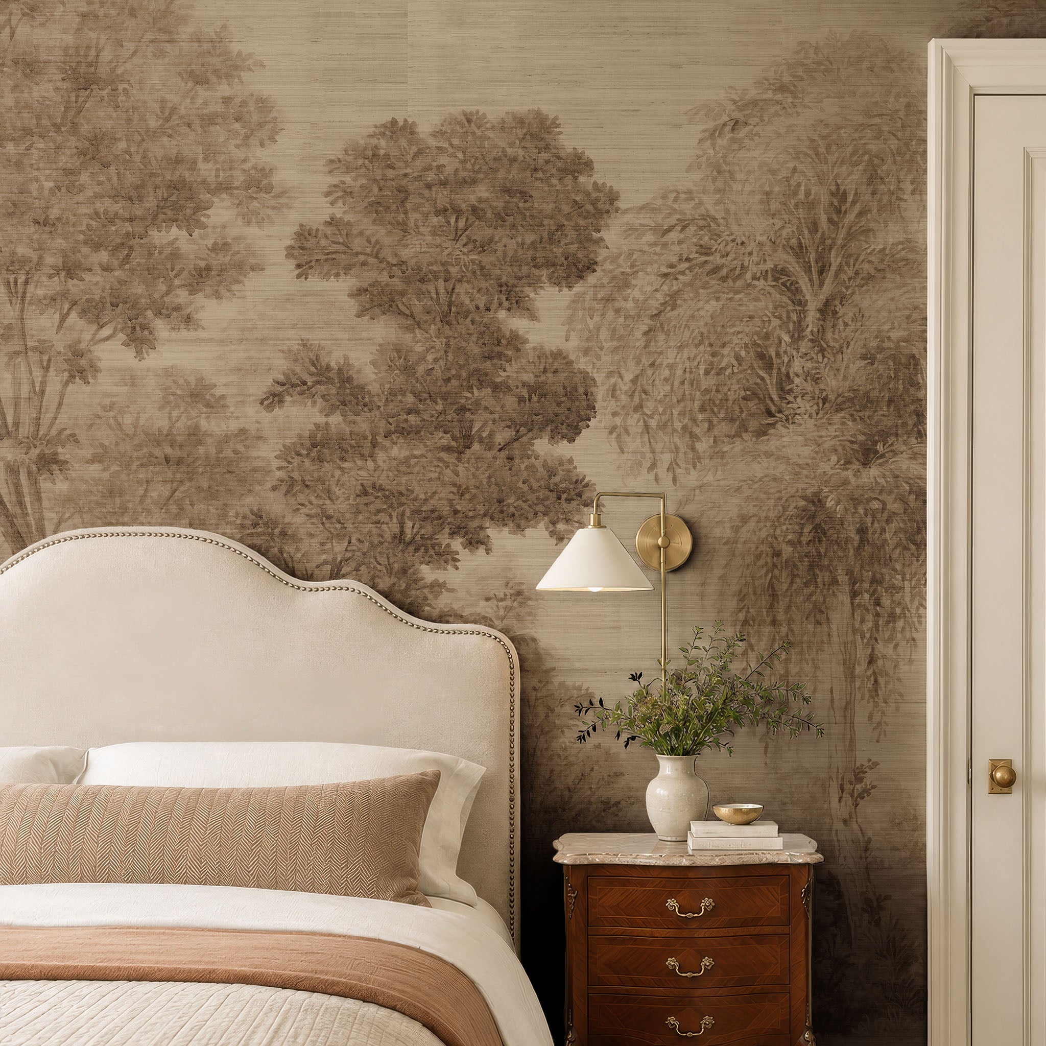 A cropped view of a bedroom featuring a panoramic grasscloth wallpaper mural of sepia-toned woodland