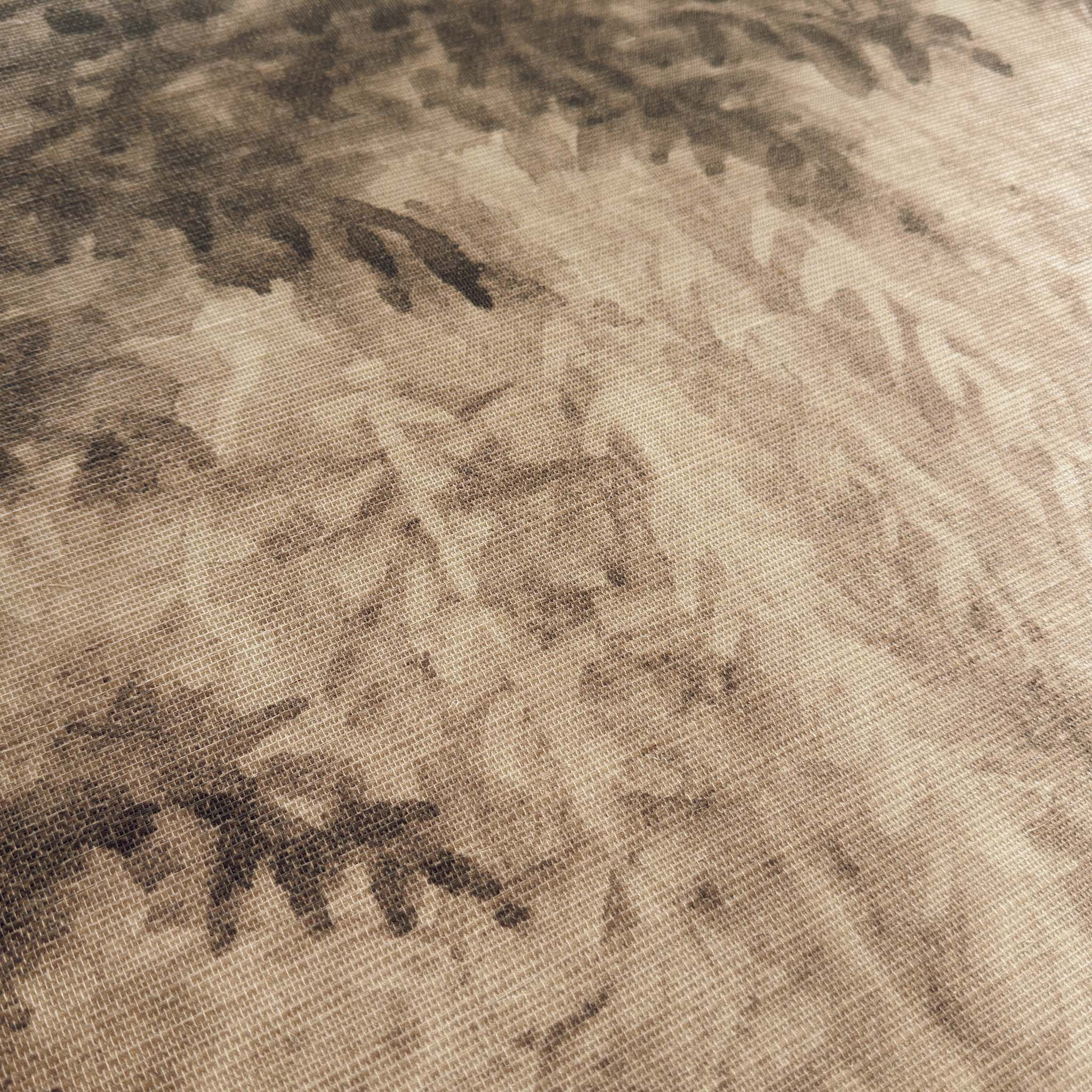 A close up view showing the detail of a grasscloth wallpaper mural which features sepia-toned woodland