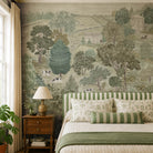 An interior bedroom featuring a panoramic grasscloth wallpaper mural of a soft green countryside with cattle and boats