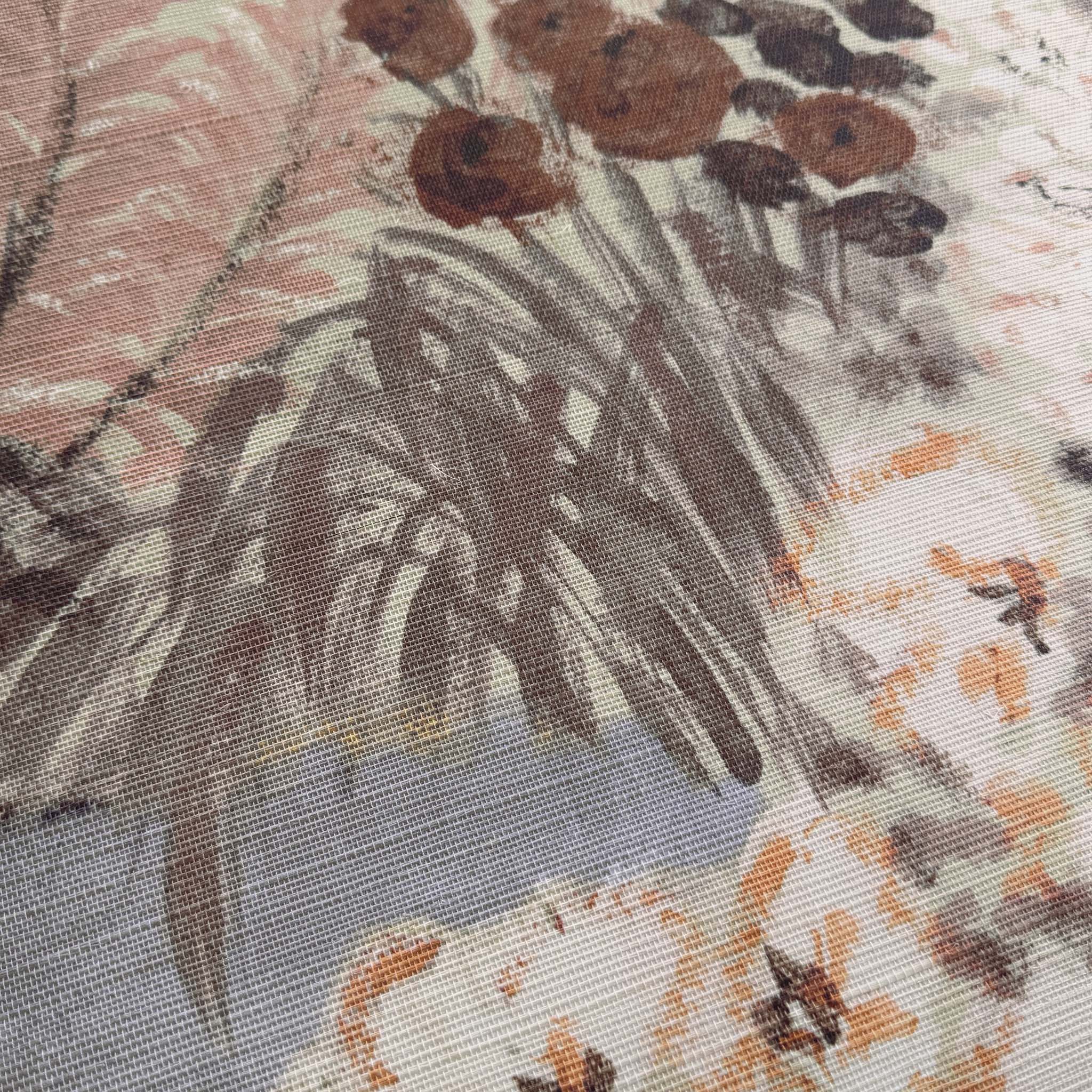 A close up view showing the detail of a grasscloth wallpaper mural which features a countryside in clay and soft plum tones