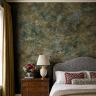 A cropped view of a bedroom featuring a panoramic pearlescent wallpaper mural of misty mural in fennel, sage, olive, indigo and ochre.