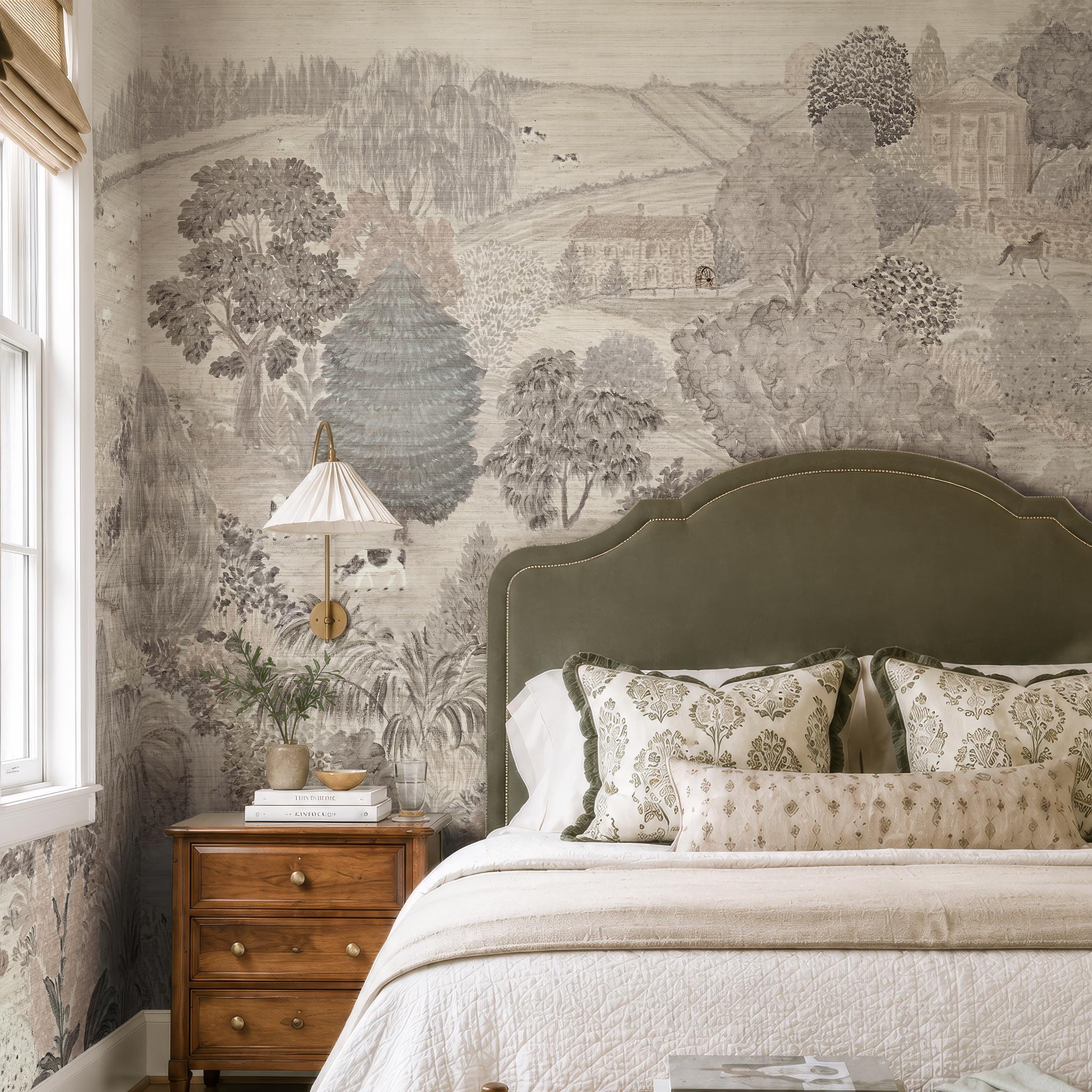 An interior bedroom featuring a panoramic grasscloth wallpaper mural of a countryside in almond, dusty rose, and mist