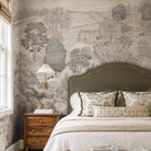 An interior bedroom featuring a panoramic grasscloth wallpaper mural of a countryside in almond, dusty rose, and mist