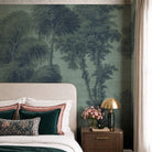A cropped view of a bedroom featuring a panoramic grasscloth wallpaper mural of deep woodland