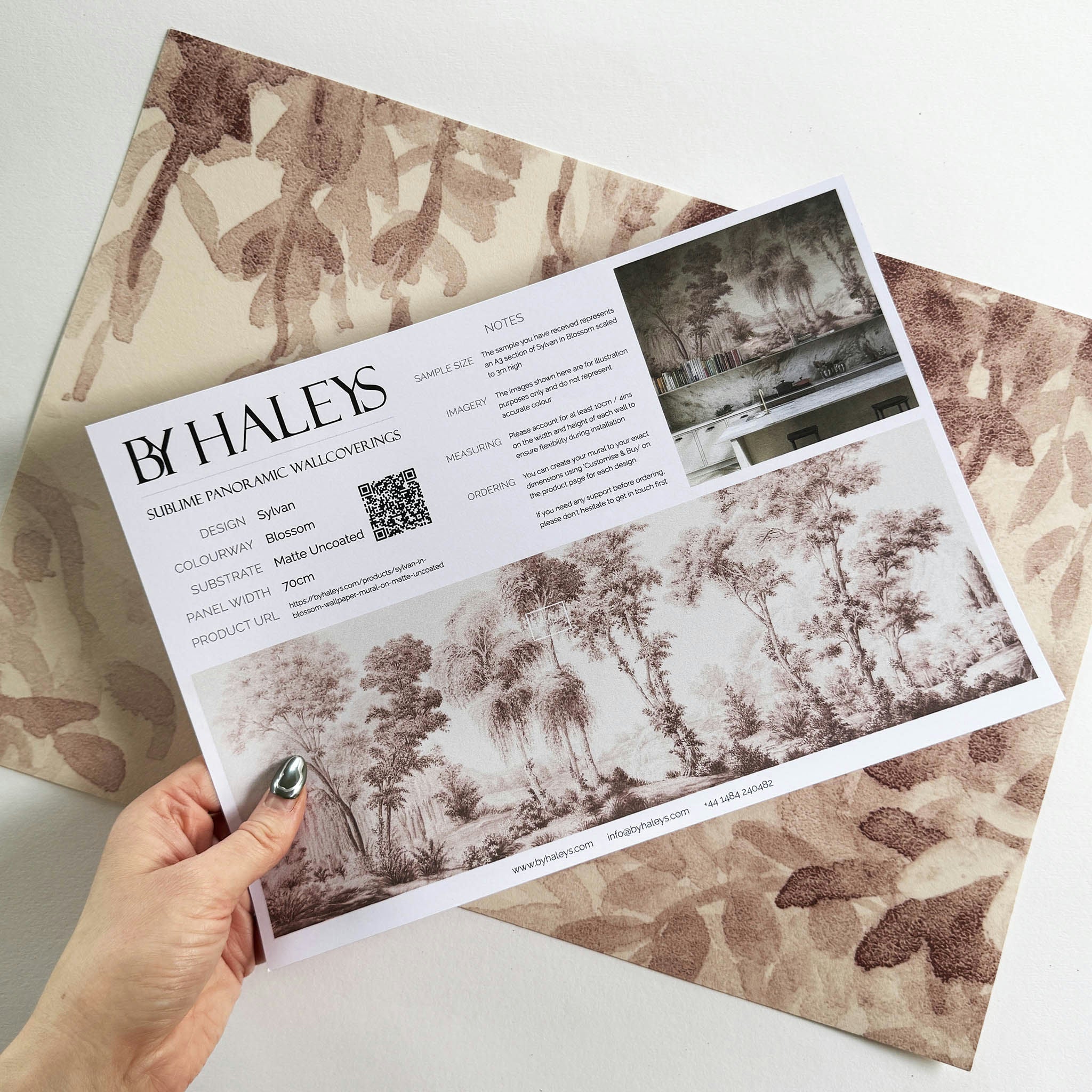 A hand showing information for a matte wallpaper mural sample which features rose forest