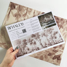 A hand showing information for a matte wallpaper mural sample which features rose forest