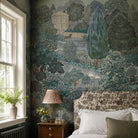 An interior bedroom featuring a panoramic grasscloth wallpaper mural of a countryside in teal, sea green and slate 